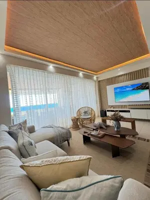 a living room with a couch and a tv at Las Olas Apartment, Juan Dolio in Guayacanes
