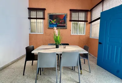 a dining room table with chairs and a vase of flowers at Colonial Home with Private Terrace and Jacuzzi in Santo Domingo