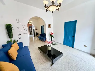 a living room with a blue couch and a table at Colonial Home with Private Terrace and Jacuzzi in Santo Domingo