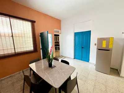 a dining room with a table and a refrigerator at Colonial Home with Private Terrace and Jacuzzi in Santo Domingo
