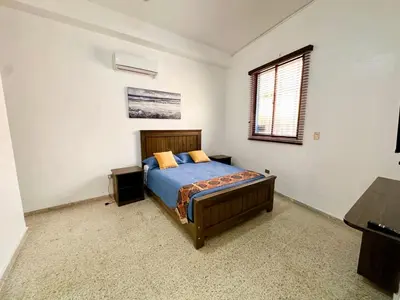 a bedroom with a bed and a window at Colonial Home with Private Terrace and Jacuzzi in Santo Domingo