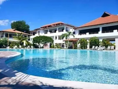 a large swimming pool in front of a building at Private studio apartment with eat in kitchen in Bayahibe