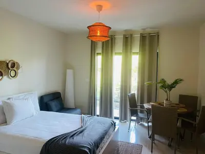 a bedroom with a bed and a table with chairs at Modern 2 Queen Beds Apartment with Garden View in Puerto Plata