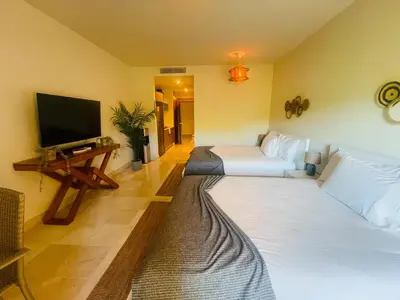 a room with two beds and a flat screen tv at Modern 2 Queen Beds Apartment with Garden View in Puerto Plata