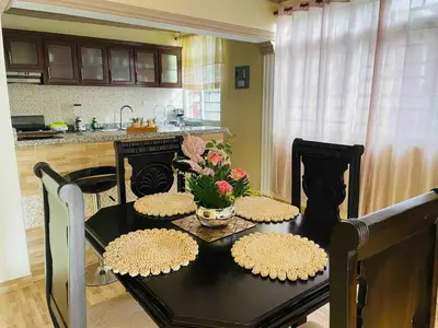 a kitchen with a black table with flowers on it at Apt 2 Bedrooms a Pasos del Malecon y la Playa in San Felipe de Puerto Plata