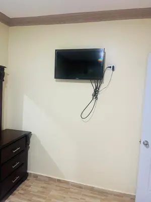 a flat screen tv hanging on a wall at Apt 2 Bedrooms a Pasos del Malecon y la Playa in San Felipe de Puerto Plata