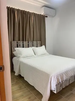 a bedroom with a white bed and a window at Luxurious 1BR apartment with ocean and mountain views, central in San Felipe de Puerto Plata