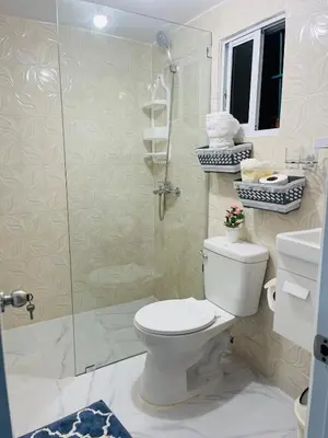 a bathroom with a toilet and a glass shower at Sabor Latino Apartment in San Felipe de Puerto Plata