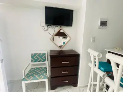a room with a dresser and a tv on a wall at Sabor Latino Apartment in San Felipe de Puerto Plata
