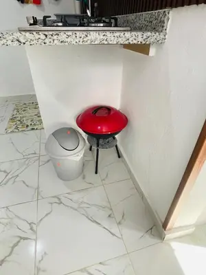 a red toilet in a corner of a room at Sabor Latino Apartment in San Felipe de Puerto Plata