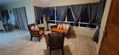 a living room with two chairs and a table at Luxury Cabarete East Condominiums in Cabarete