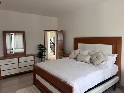 a bedroom with a bed and a dresser and a mirror at jardines de caleta in La Romana