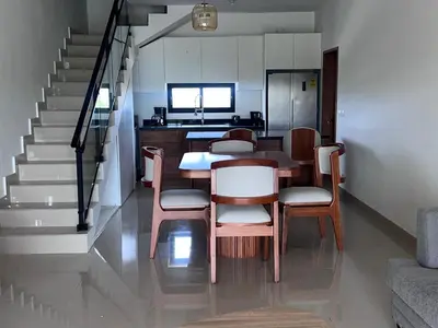 a dining room with a table and chairs and stairs at jardines de caleta in La Romana