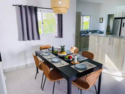 a dining room with a black table and chairs at Apartamento Armonía-K-204 in Las Terrenas
