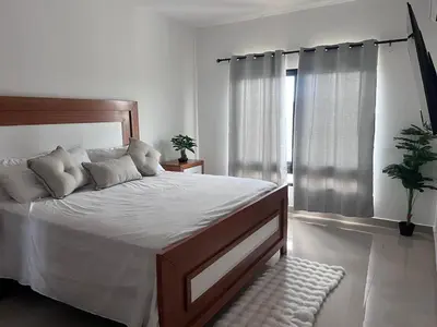 a bedroom with a large bed with white sheets at jardines de caleta 7 in La Romana