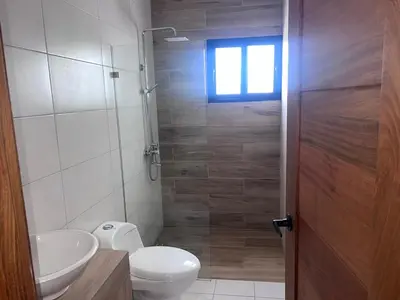 a bathroom with a toilet and a sink and a window at jardines de caleta 7 in La Romana