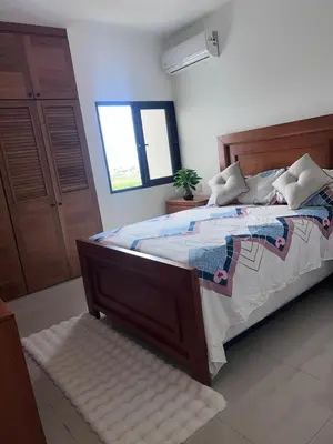 a bedroom with a large bed and a window at jardines de caleta 7 in La Romana