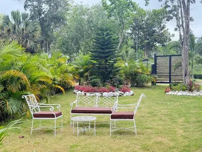 two chairs and a table in a garden at Villa refugio de paz in Bayaguana