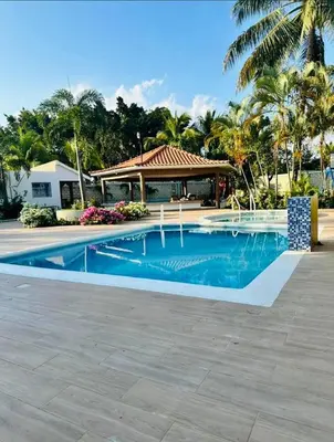 a swimming pool in front of a house at Charming villa in San Pedro de Macorís