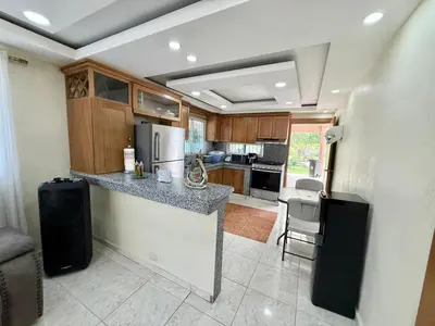 a kitchen with a counter with a refrigerator and cabinets at Villa San Pedro in San Pedro de Macorís
