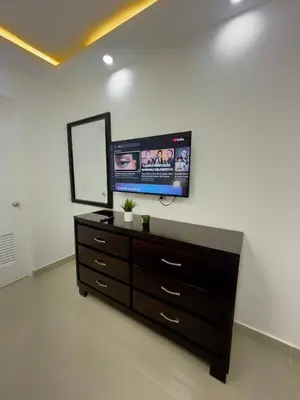 a living room with a tv and a dresser at Encanto - La Romana near Caleta beach in La Romana