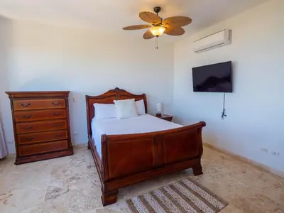 a bedroom with a bed and a ceiling fan at Villa Emoción Del Mar - Beachfront Luxury Villa