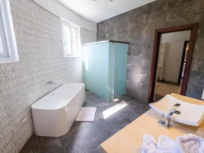 a bathroom with a bath tub and a sink at Villa Emoción Del Mar - Beachfront Luxury Villa