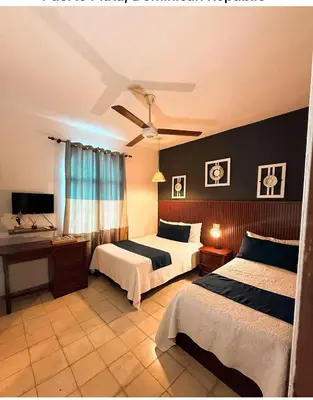 a bedroom with two beds and a ceiling fan at Hotel Montesilva in Puerto Plata