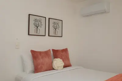 a white couch with three pictures on the wall at Rustic Charm, Apartment in the heart of Santiago in Santiago de los Caballeros