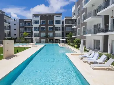 a swimming pool in front of a apartment building at Escape perfecto, punta cana in Punta Cana
