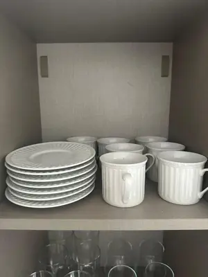 a shelf with white plates and bowls and glasses at Escape perfecto, punta cana in Punta Cana