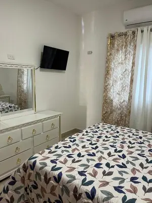 a bedroom with a bed and a dresser and a mirror at Residencial Torre del Atlantico in Puerto Plata