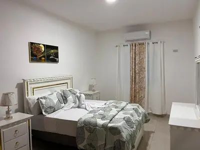 a white bedroom with a bed and a sink at Residencial Torre del Atlantico in Puerto Plata