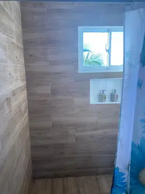a bathroom with a wooden wall with a window at Mi Rinconcito in Colorado