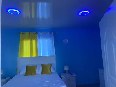a blue room with a bed with a yellow curtain at Mi Rinconcito in Colorado