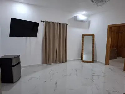 a living room with a television and a mirror at Villa with Pool Terrace and 3 minutes to the beach in Puerto Plata