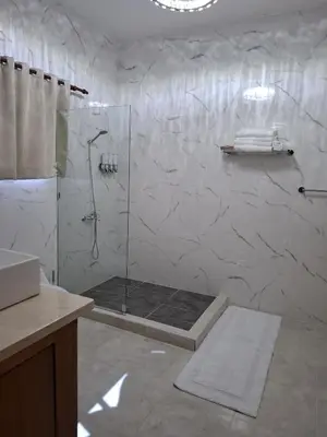 a bathroom with a shower with a glass door at Villa with Pool Terrace and 3 minutes to the beach in Puerto Plata