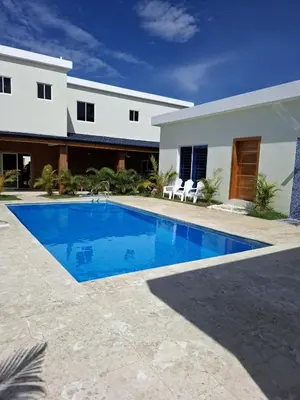 a swimming pool in front of a house at Villa with Pool Terrace and 3 minutes to the beach in Puerto Plata