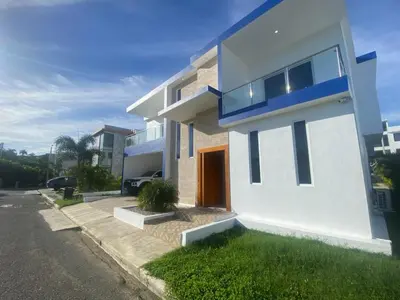 a white house with a red door on a street at Villa with Pool Terrace and 3 minutes to the beach in Puerto Plata