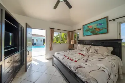 a bedroom with a bed and a flat screen tv at 6BR, Jacuzzi, Ocean View, Solar Backup Power in Sosúa
