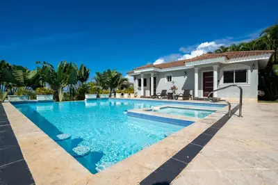 a swimming pool in front of a house at 6BR, Jacuzzi, Ocean View, Solar Backup Power in Sosúa