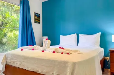 a bedroom with a bed with a blue wall at Renaissance Residence Cabarete in Cabarete