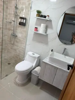 a bathroom with a toilet and a sink and a shower at Luxurious Apartment in Santiago de los Caballeros