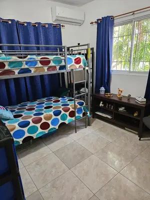 a bedroom with two bunk beds with blue curtains at Garden II in Boca Chica