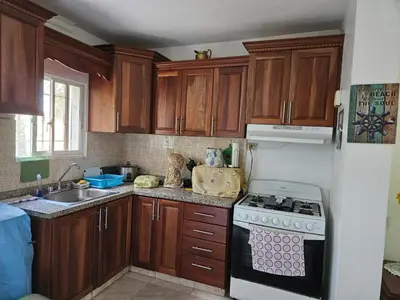 a kitchen with wooden cabinets and a stove top oven at Garden II in Boca Chica