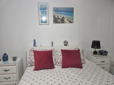 a bedroom with a bed with two red pillows at Garden II in Boca Chica