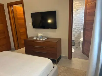a bedroom with a bed and a flat screen tv at REFA - 404 · Luxury 1BR Suite in Piantini | Modern • Pool • Gym in Santo Domingo