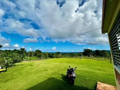 a motorcycle parked in a field in a grassy field at Apartamentos-Oliver in Las Galeras