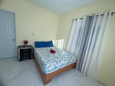 a bedroom with a bed with blue pillows at Apartamentos-Oliver in Las Galeras