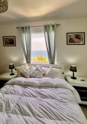a bedroom with a large bed with a large window at Malecón view mar apartment in Colorado